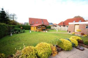 a yard with a house and some bushes at Ferienwohnung Frieda, 65207 in Moormerland