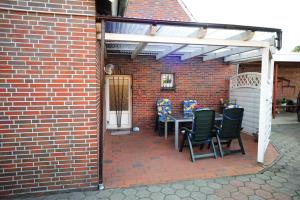 un patio con tavolo e sedie in un edificio in mattoni di Ferienwohnung Frieda, 65207 a Moormerland