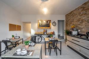 a kitchen with tables and chairs and a brick wall at Travel B&B in Pisa