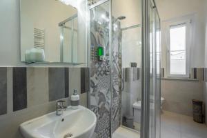 uma casa de banho com um lavatório e um chuveiro em Travel B&B em Pisa