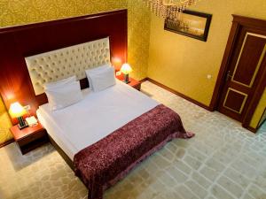 um quarto com uma cama grande e 2 candeeiros em Clover Hotel Baku em Baku