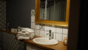 uma casa de banho com lavatório, espelho e toalhas em Au cœur de Fontaine em Fontaine-Française