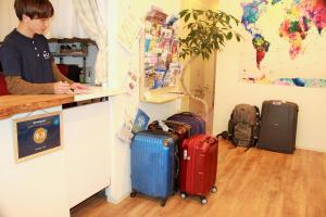 een man aan een balie met bagage bij Hostel TOKI in Fukuoka