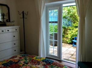- une chambre avec un lit et une porte coulissante en verre dans l'établissement River Walk, à Lyme Regis