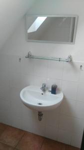 uma casa de banho com um lavatório branco e um espelho. em Tradiční hostinec em Sněžné