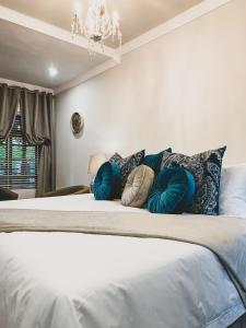 a bedroom with a bed with pillows and a chandelier at Danlee Overnight Accommodation in Polokwane