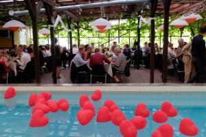 una piscina con corazones de papel rojo delante de una multitud de personas en Danninghus, en Vindeby