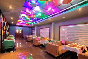a restaurant with tables and chairs and a colorful ceiling at Hotel Ceasar Palace in Thodupuzha