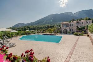 a resort with a swimming pool and mountains in the background at Salakos Villas in Sálakos