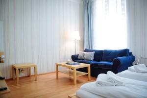 ウィーンにあるAugarten Residencesの青いソファとテーブルが備わるホテルルームです。