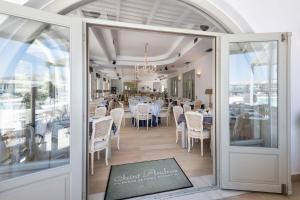 a dining room with white tables and chairs at Saint Andrea Seaside Resort - Adults Only in Naousa