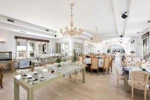 a large dining room with tables and chairs at Saint Andrea Seaside Resort - Adults Only in Naousa