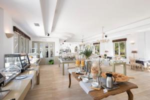 a large room with tables with vases on them at Saint Andrea Seaside Resort - Adults Only in Naousa