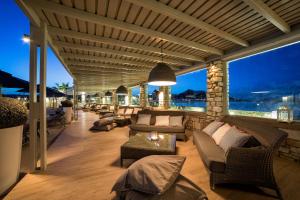 a living room with couches and chairs on a balcony at Saint Andrea Seaside Resort - Adults Only in Naousa
