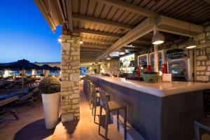 a restaurant with a bar with chairs and tables at Saint Andrea Seaside Resort in Naousa