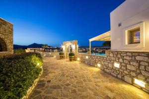 a house with lights on the side of it at Saint Andrea Seaside Resort - Adults Only in Naousa