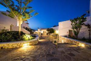 a pathway leading to a villa at night with lights at Saint Andrea Seaside Resort - Adults Only in Naousa