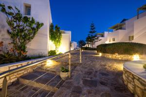 a pathway leading to a house at night with lights at Saint Andrea Seaside Resort - Adults Only in Naousa