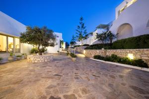 a stone patio in front of a house at night at Saint Andrea Seaside Resort - Adults Only in Naousa