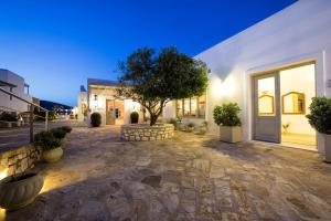 a house with a tree in the middle of a courtyard at Saint Andrea Seaside Resort - Adults Only in Naousa