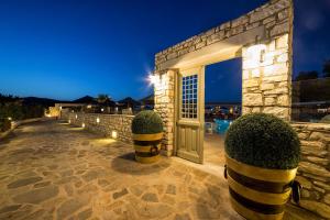 a entrance to a house with a door and some bushes at Saint Andrea Seaside Resort - Adults Only in Naousa