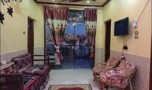 uma sala de estar com sofás e uma grande janela em El-amin Guest House em Aswan