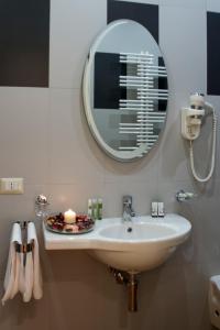 y baño con lavabo y espejo. en Il Portico Luxury B&B, en Cassano delle Murge