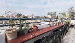 a table with chairs and potted plants on a balcony at Florentine Backpackers Hostel - ages 18-55 in Tel Aviv