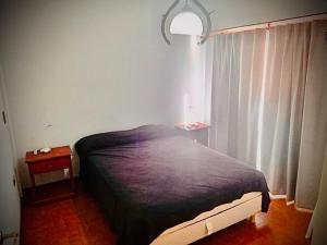 a bedroom with a bed and a window at Departamento Víctoria in Mar del Plata