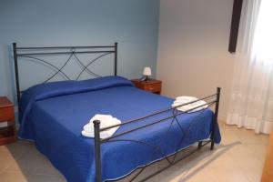 a bedroom with a blue bed with blue sheets at Case Beach & Family in Marausa