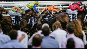 a group of horses and jockeys racing on a track at Melbourne short stay - Caulfield station, Monash Uni in Melbourne