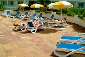 a group of people laying in lawn chairs and umbrellas at Stil Bonsai in Can Picafort