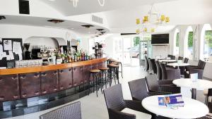 un restaurante con un bar con mesas y sillas en Stil Bonsai, en Can Picafort