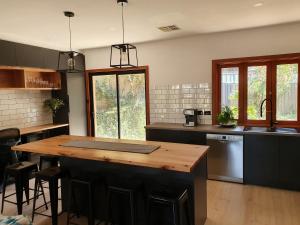 a kitchen with a wooden island in the middle at Seacliff Park Holiday Home in Seacliff