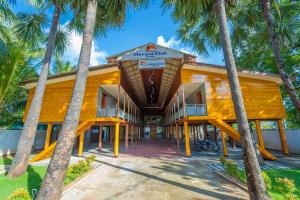 ein Gebäude mit Palmen davor in der Unterkunft Havana Club Resort in Trincomalee