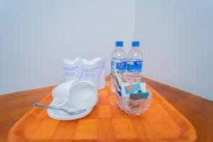 ein Holztisch mit Milch und einer Flasche Wasser in der Unterkunft Havana Club Resort in Trincomalee