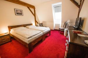 a bedroom with a bed and a red carpet at Hotel Europa in Liptovský Mikuláš +28 photos