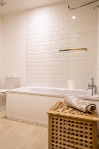 baño blanco con bañera y aseo en Cavernous open plan town house in st Leonards en St. Leonards