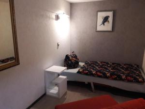 ein kleines Zimmer mit einem Bett und einem Spiegel in der Unterkunft Logis Am Park in Dessau