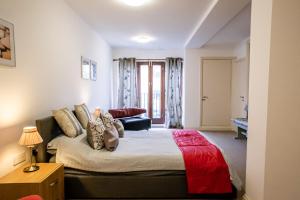 sypialnia z dużym łóżkiem i czerwonym kocem w obiekcie Cavernous open plan town house in st Leonards w mieście St Leonards-on-Sea