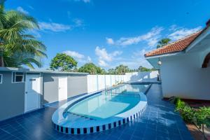 una piscina al lado de una casa en Havana Club Resort, en Trincomalee