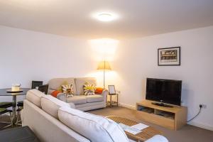 a living room with a couch and a tv at Stylish modern Mews house in central St Leonards in Hastings
