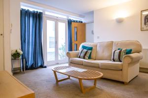 ein Wohnzimmer mit einem Sofa und einem Couchtisch in der Unterkunft Stylish modern Mews house in central St Leonards in Hastings