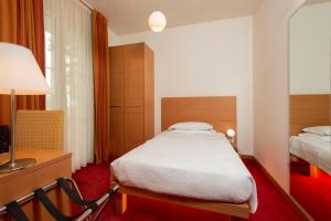 A bed or beds in a room at Accademia Hotel