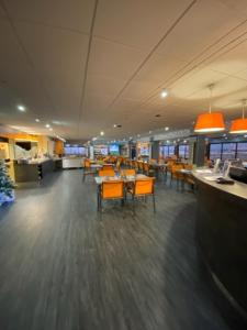 ein Restaurant mit Tischen und Stühlen in einer Cafeteria in der Unterkunft Hôtel De La Plage in Calais