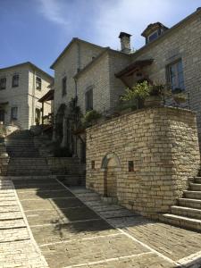 a stone building with stairs and a building at Artsistas Houses in Aristi