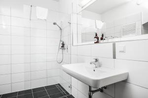 a white sink sitting under a mirror in a bathroom at Hotel Weitzer Graz in Graz
