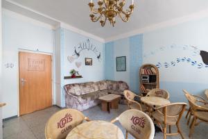 a living room with a couch and chairs and a chandelier at Hostel Dakura in Prague