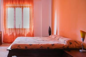 a bedroom with a bed with an orange wall at Marisal Accomodation in Alghero