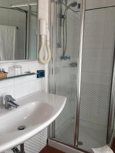a bathroom with a shower and a sink at Cala Rosa Club Hotel in Stintino